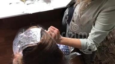 个人企业家在家里提供服务。 理发师画一个女人的头发。